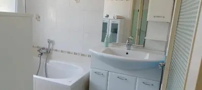 a bathroom with a sink and a mirror and a tub at 7 Flower Street Apartment in Šempeter pri Gorici