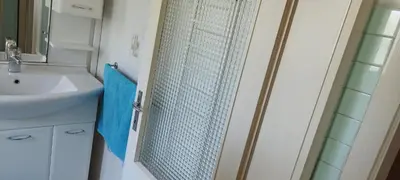 a bathroom with a shower with a sink and a mirror at 7 Flower Street Apartment in Šempeter pri Gorici