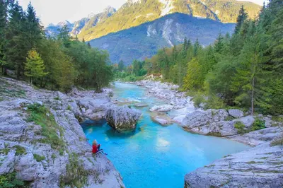 a person in a kayak in a river with blue water at 7 Flower Street Apartment in Šempeter pri Gorici