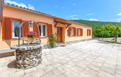 a house with a stone driveway in front of it at Amazing Home In Podgorje in Podgorje