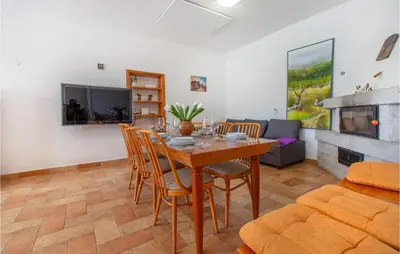 a dining room with a table and chairs and a couch at Amazing Home In Podgorje in Podgorje