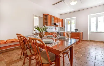 a dining room with a wooden table and chairs at Amazing Home In Podgorje in Podgorje