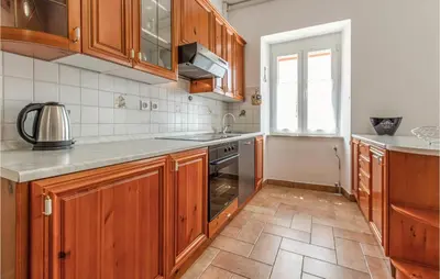 a kitchen with wooden cabinets and a sink at Amazing Home In Podgorje in Podgorje