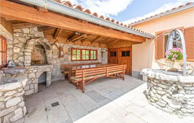 a patio with a wooden bench and a stone fireplace at Amazing Home In Podgorje in Podgorje