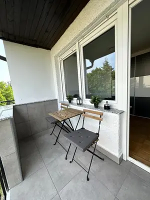 a patio with a table and chairs on a balcony at Granny's Vintage Chic in Maribor