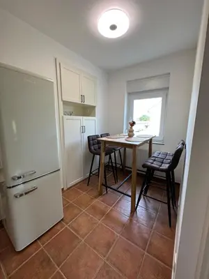 a kitchen with a table and chairs and a refrigerator at Granny's Vintage Chic in Maribor