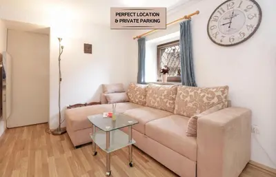 a living room with a couch and a clock on the wall at Spring rest in Bled