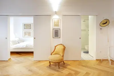 a bedroom with a bed and a chair at Stylish Apartment in Historical Center in Ljubljana