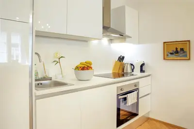 a kitchen with white cabinets and a sink at Stylish Apartment in Historical Center in Ljubljana