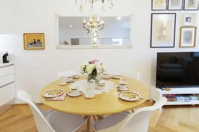 a dining room with a table and chairs and a television at Stylish Apartment in Historical Center in Ljubljana