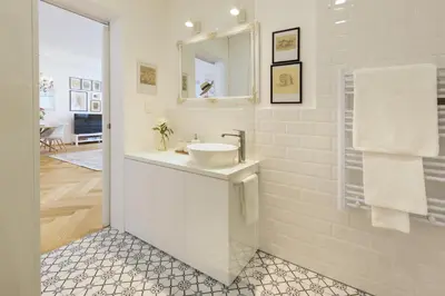 a white bathroom with a sink and a mirror at Stylish Apartment in Historical Center in Ljubljana