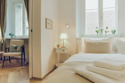 a bedroom with a bed with white sheets and a window at Stylish Apartment in Historical Center in Ljubljana