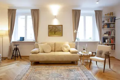a living room with a couch and two windows at Stylish Apartment in Historical Center in Ljubljana