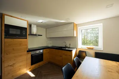 a kitchen with a table and a sink and a window at Holiday House Chilly in Kotlje