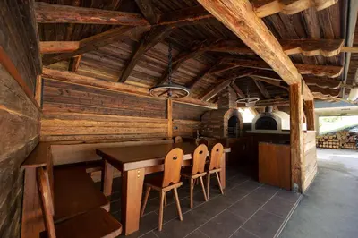 a dining room with a table and chairs in a cabin at Holiday House Chilly in Kotlje