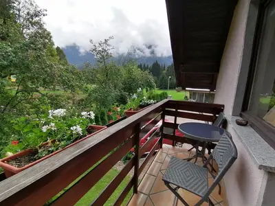 a balcony with a table and chairs and a view at Apartments Mertelj in Kranjska Gora