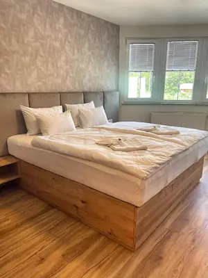 a large bed with a wooden frame in a bedroom at Vila Urbana Luxury Apartments in Lesce