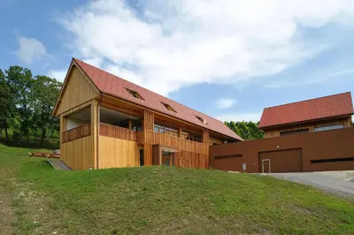 a building with a red roof on top of a hill at Vino Valdhuber Apartments in Svečina