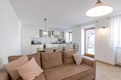 a living room with a couch and a kitchen at Vila Sistiana in Kostanjevica na Krasu