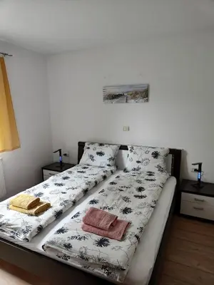 a bed with black and white sheets and pillows at Apartma Nena in Bovec