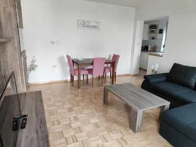 a living room with a table and chairs and a couch at Apartma Nena in Bovec