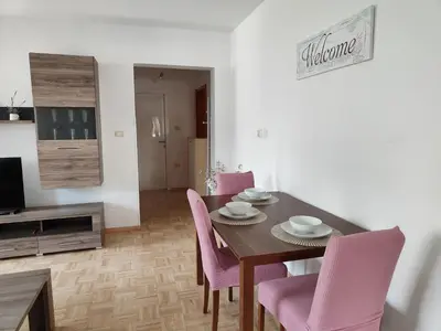 a dining room with a table and pink chairs at Apartma Nena in Bovec