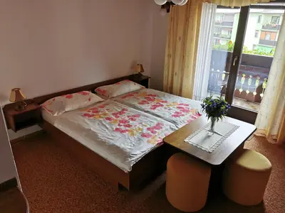 a bedroom with a bed and a table and a window at Apartment Žvab in Bohinj