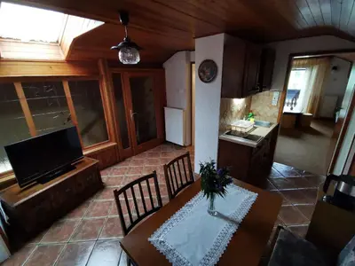 a kitchen and dining room with a table and chairs at Apartment Žvab in Bohinj