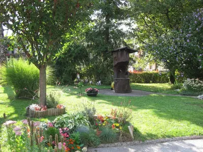 a garden with a bird bath and some flowers at Apartment Žvab in Bohinj
