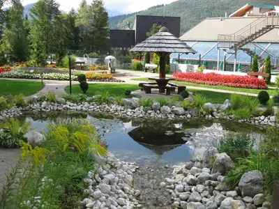 a pond with an umbrella in a garden at Apartment Žvab in Bohinj