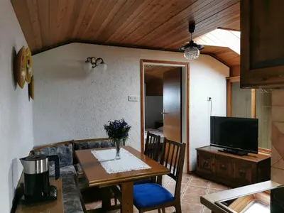 a dining room with a table and a television at Apartment Žvab in Bohinj