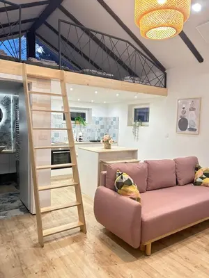 a loft bed in a living room with a couch at Apartma Tany in Ljubljana