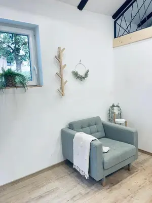 a living room with a blue couch and a window at Apartma Tany in Ljubljana