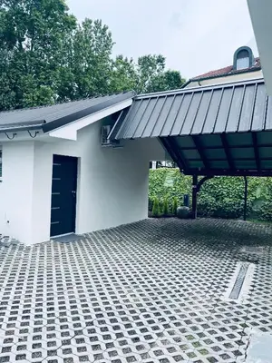 a white house with a blue door and a patio at Apartma Tany in Ljubljana