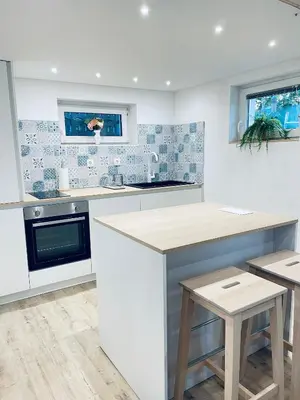 a kitchen with white and blue tiles on the wall at Apartma Tany in Ljubljana