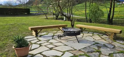 a bbq and two benches and a grill at Glamping - Kamp Steska in Žalec