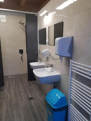 a bathroom with two sinks and a mirror and a trash can at Glamping - Kamp Steska in Žalec