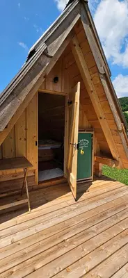 a large wooden building with a door on a deck at Glamping - Kamp Steska in Žalec
