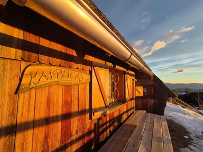 a wooden building with a sign on the side of it at Koča Velika Planina - Chalet Kamrica in Stahovica