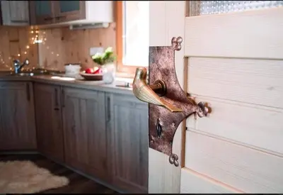 a wooden door with a door handle in a kitchen at Koča Velika Planina - Chalet Kamrica in Stahovica
