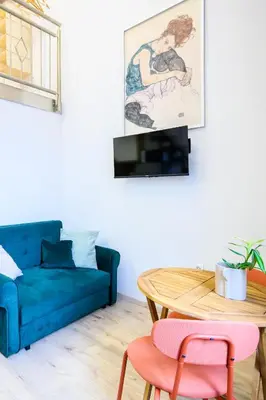 a living room with a blue couch and a table at The Amazing Loft in Ljubljana