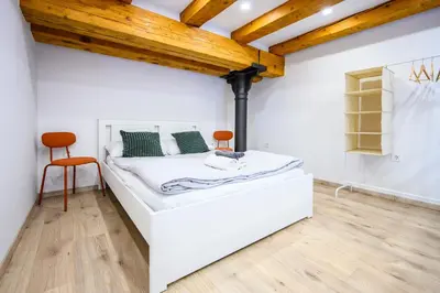 a white bed in a room with a wooden ceiling at The Amazing Loft in Ljubljana