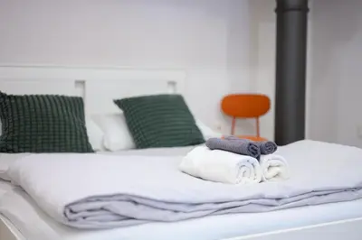 a bed with towels and a chair on it at The Amazing Loft in Ljubljana