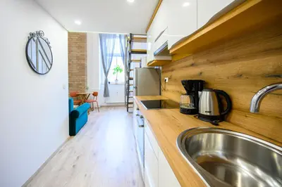 a kitchen with a stainless steel sink and wooden counters at The Amazing Loft in Ljubljana