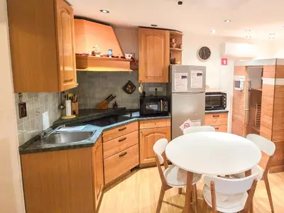 a kitchen with a table and a white table and chairs at House Banovci in Banovci