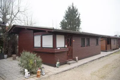 a wooden cabin with windows on the side of it at House Banovci in Banovci