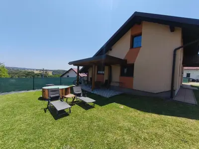 a house with a table and chairs in the yard at Guesthouse and Wellness VINEA in Spodnji Ivanjci