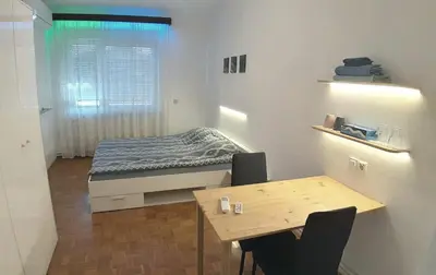 a small room with a bed and a table at ROOMserv in Ljubljana