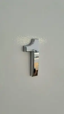 a silver faucet on a white wall at ROOMserv in Ljubljana