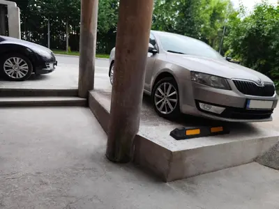 a car parked in a parking lot next to a pole at ROOMserv in Ljubljana